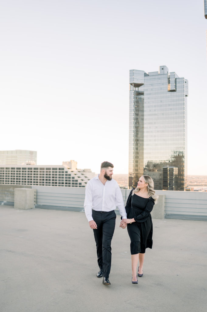 guy and girl walking towards the camera on parking garage with scenic views of fort worth