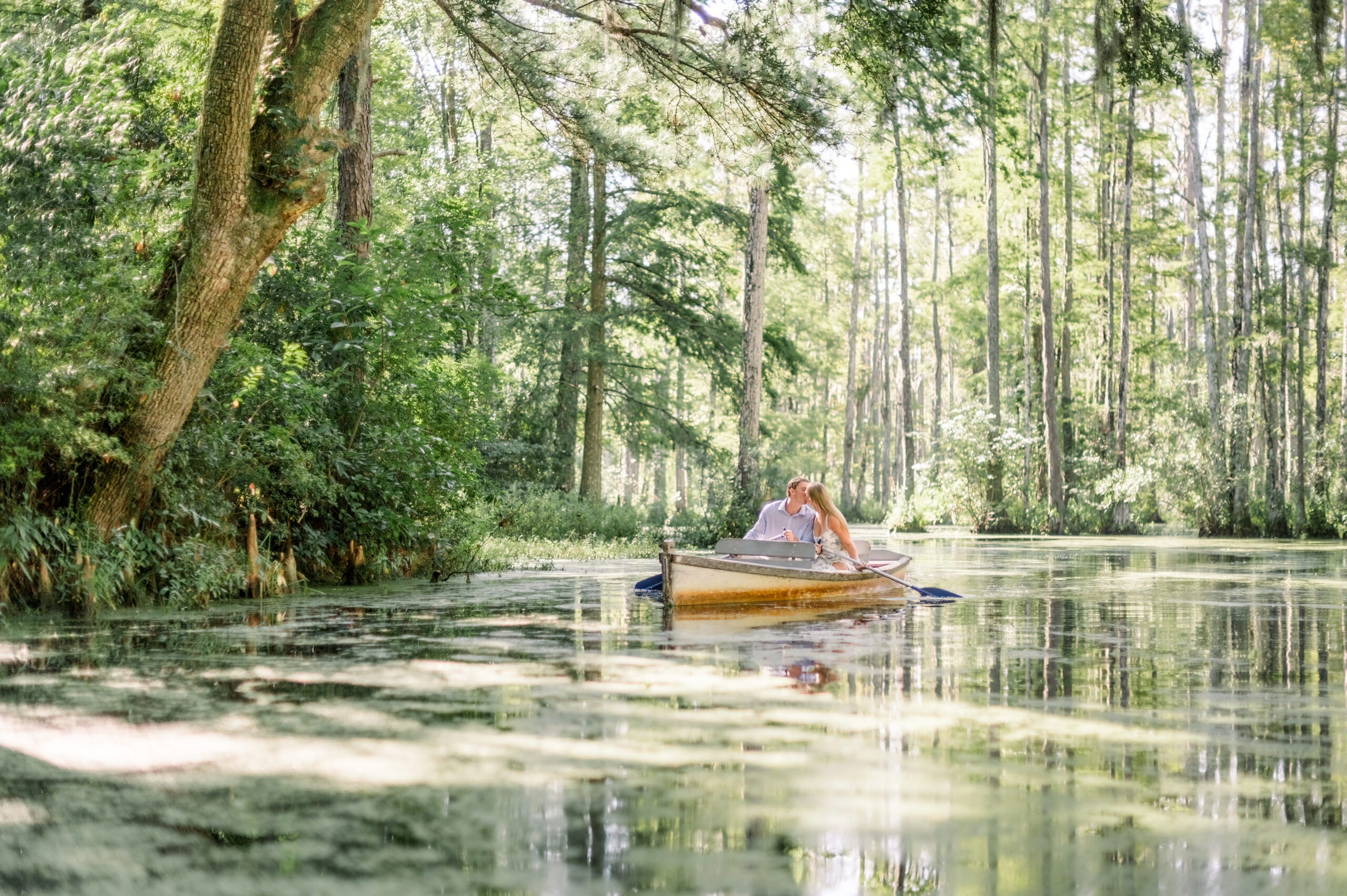 couple kissing in boat at cypress gardens in charleston south carolina, notebook inspired engagement shoot