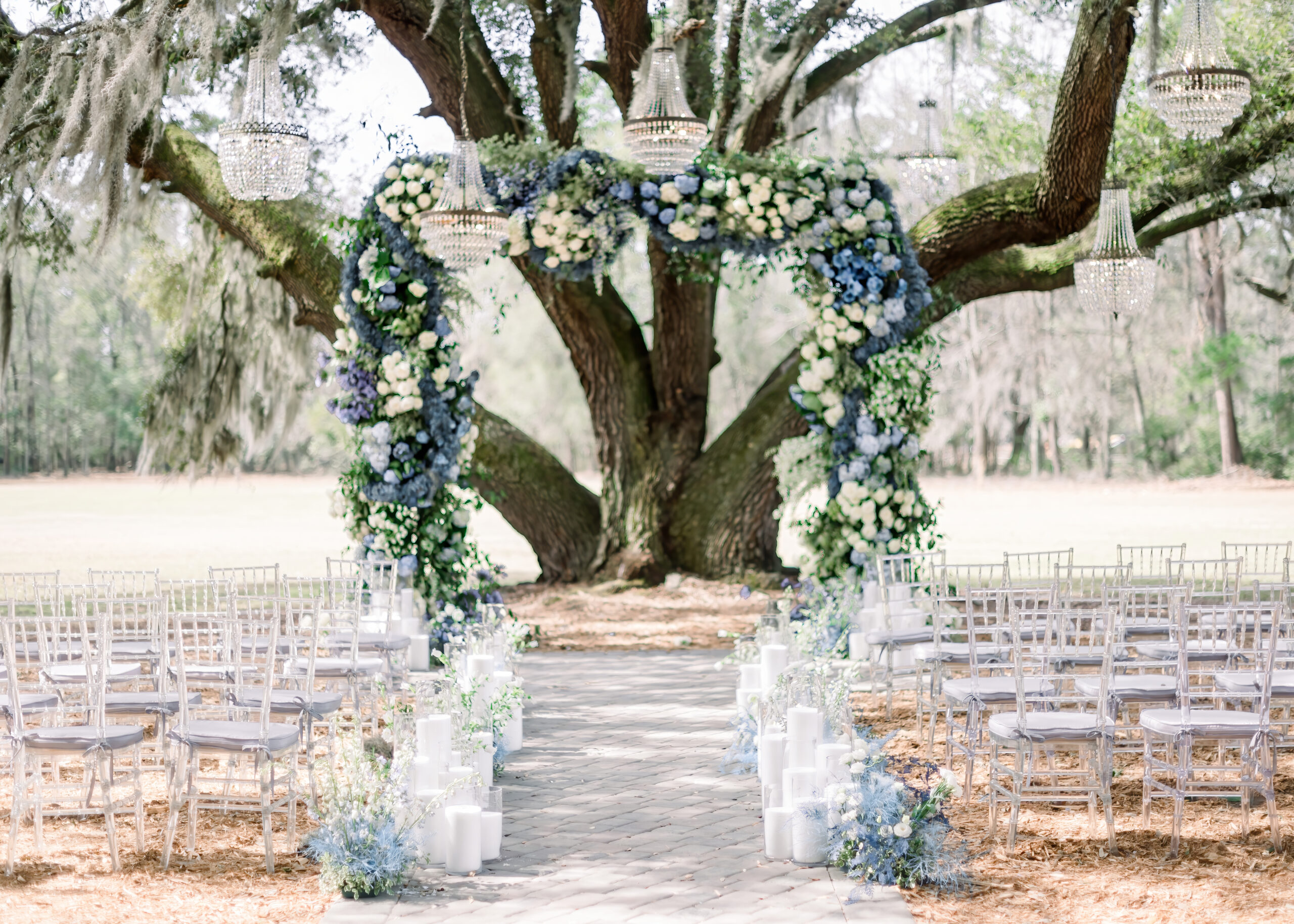 tall blue floral arch in front of an oak tree at hewitt oaks blue dream