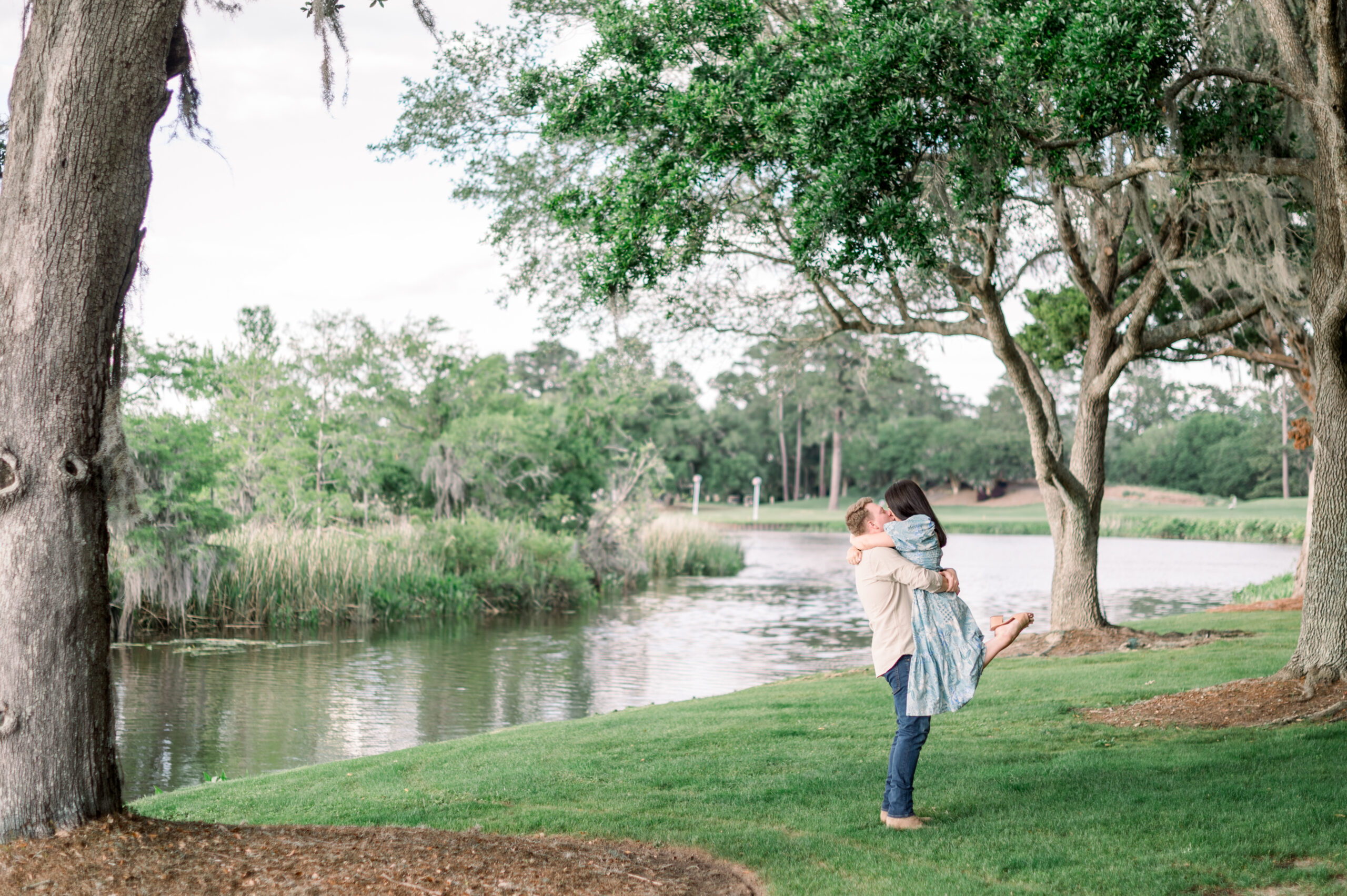 couple kissing under a tree by the river