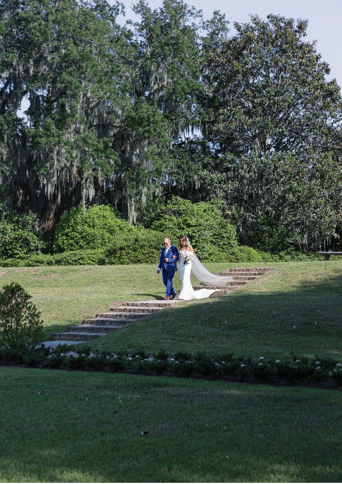 bride walking down steps with father at middleton place