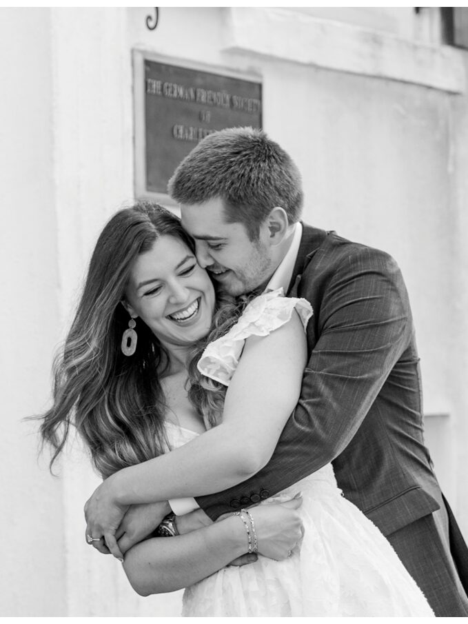 couple hugging on chalmers street in charleston south carolina for an engagement session