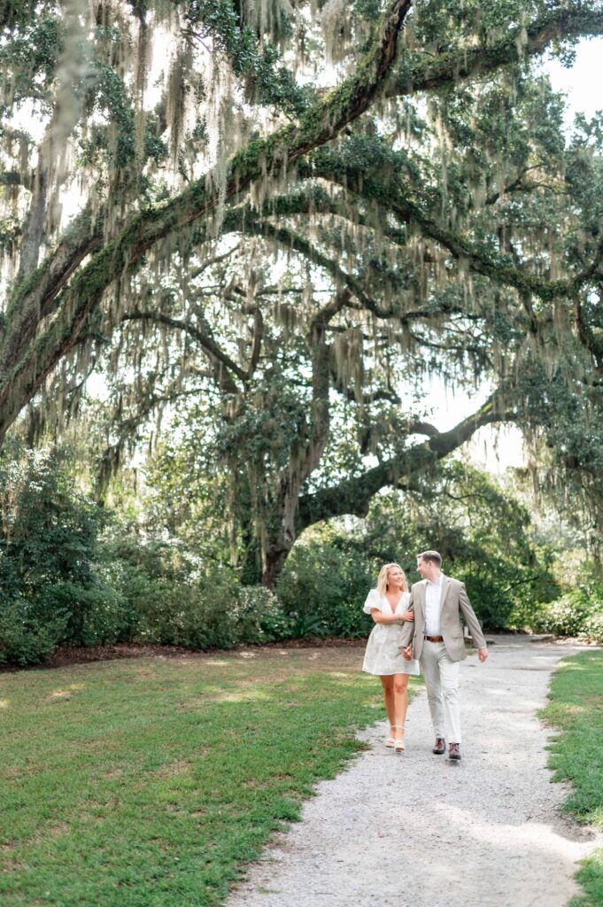 Couple walking through Magnolia Plantation gardens during engagement session