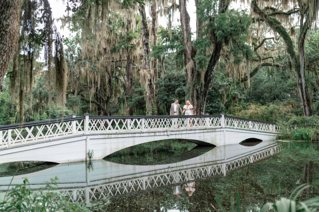 Couple laughing on Magnolia Plantation white bridge during engagement session